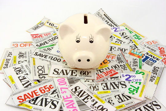 Piggy Bank On Pile Of Money Saving Grocery Coupons