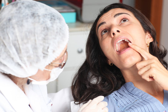 Patientin zeigt Zahnarzt wo es schmerzt