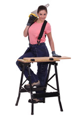 Girl with a saw at a workbench