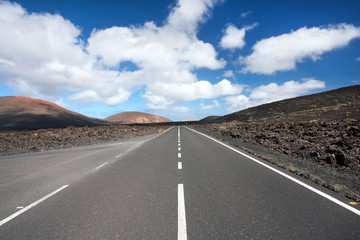 Paved road that runs in the middle of a desert landscape