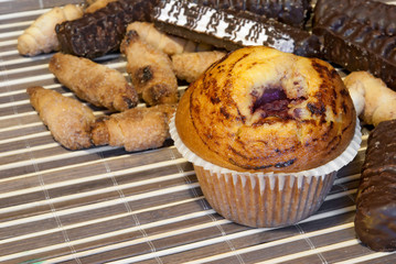 Fruitcake with a cherry, around different confectionery