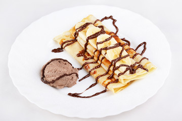 Thin pancakes with banana, ice cream and chocolate