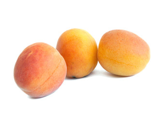 three apricots on white background