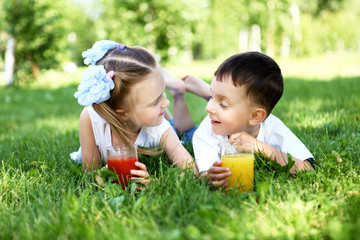 Little brother and sister in summer park