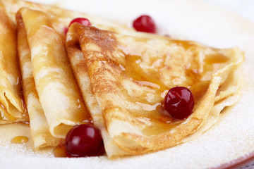 Pancakes with cranberry berries and honey on a plate