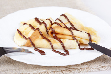 Thin pancakes with banana and chocolate