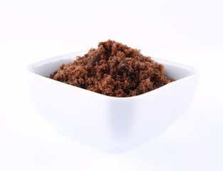 Brown sugar in a bowl on a white background