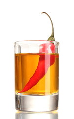 glass of pepper vodka and red chili pepper isolated on white