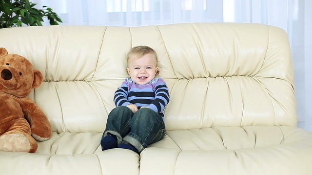 Smiling baby boy sitting on the couch