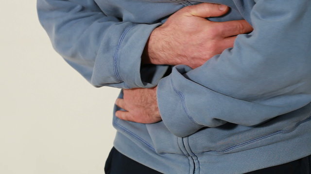 Man holding his hands over his aching stomach