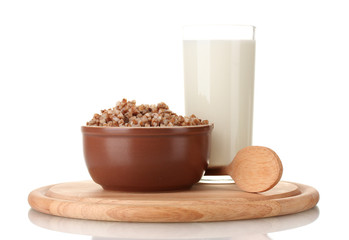 Boiled buckwheat in a brown bowl a glass of milk