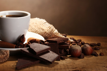 coffee cup and beans, cinnamon sticks, nuts and chocolate