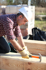 Man working on large wooden structure