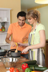 Fototapeta na wymiar Couple preparing a meal together in their kitchen