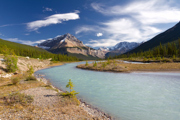 Canadian landscape with river, mountains and cloudy sky