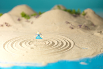 Fototapeta na wymiar little toy angel in miniature landscape