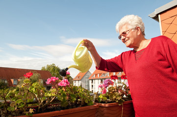 seniorin gießt Blumen