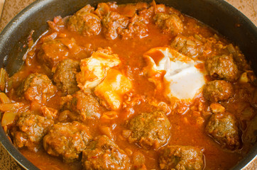 Moroccan kefta with eggs in tomato sauce  tajine