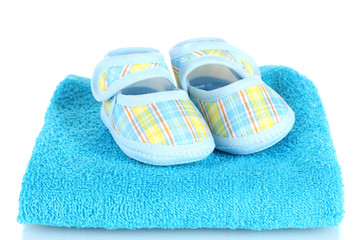 Blue baby booties on blue towel isolated on white