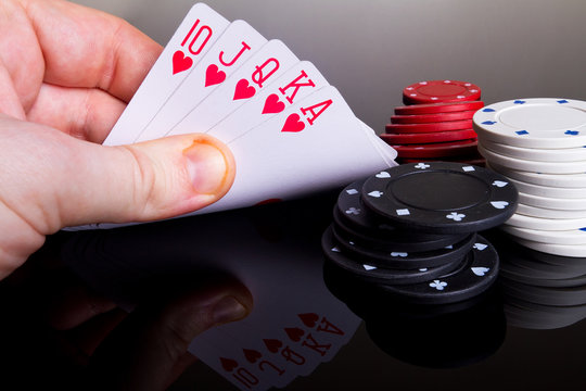Royal poker in the hand with reflection