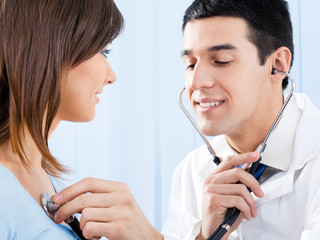 Doctor with stethoscope and patient at office