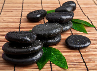 Obraz na płótnie Canvas black stone with leaf. massage stones