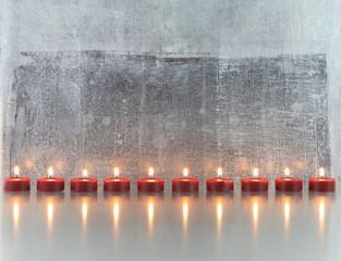 Kerzenreihe vor abstraktem Hintergrund