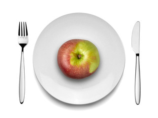 Red apple on white plate with knife and fork,