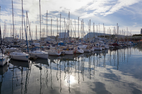sailboats reflect in a Barcelona harbor