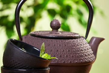 Obraz na płótnie Canvas Kettle and closeup fresh mint leaves in a tea cup