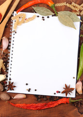 notebook for recipes and spices on wooden table