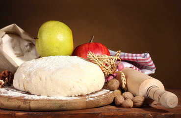 ingredients for homemade pie on wooden table on brown background