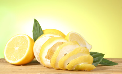 Fototapeta na wymiar ripe lemons with leaves on wooden table on green background