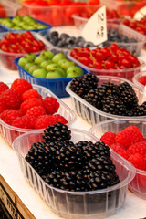 Fototapeta na wymiar A selection of berries and fruit in a rainbow of colors at an ou