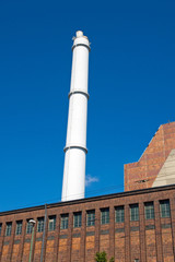 White smokestack and red brick building