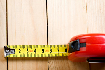 Tape measure on wooden background