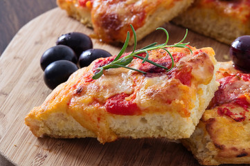 Focaccia with tomato and black olives.