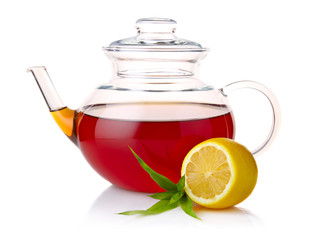 Teapot with black tea, green leaves and lemon slices isolated on