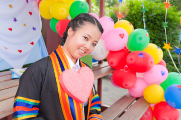 Graduated Asian girl with balloons