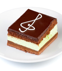 Chocolate cake with a treble clef sign made with cream. Isolated