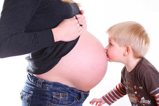 kind k&uuml;sst babybauch der schwangeren mutter