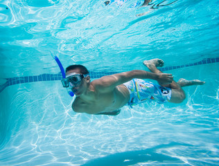 Young Man Swimming Under Water In Pool