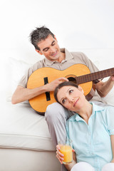 Mann spielt Gitarre für Frau