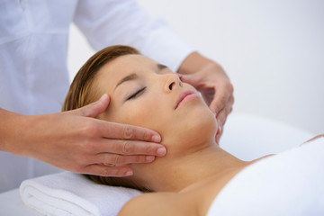 Woman laying on back have face massaged