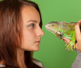 A young girl stares at iguana