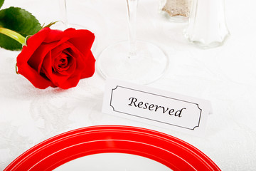Close up of Reserved Restaurant Table with Red Rose