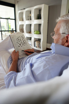 Senior Doing A Crossword In A Magazine