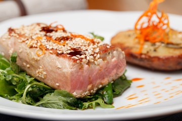 Fried tuna steak and potatoes on the plate