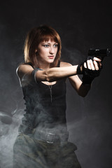 Sexy woman holding gun with smoke