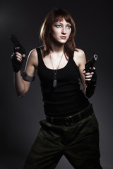 Sexy woman holding gun on gray